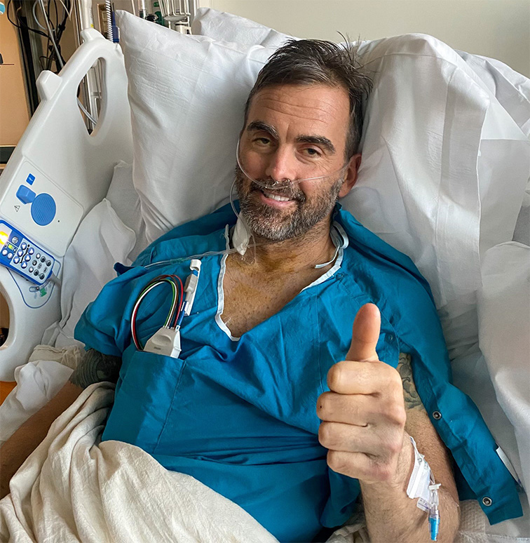 Tyson in hospital bed with thumb up