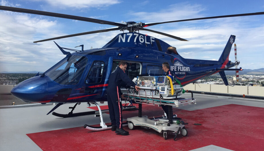 Neonatal Pediatric team load an infant in an incubator into a waiting helicopter