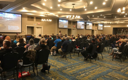 A large conference of people listening to a speaker