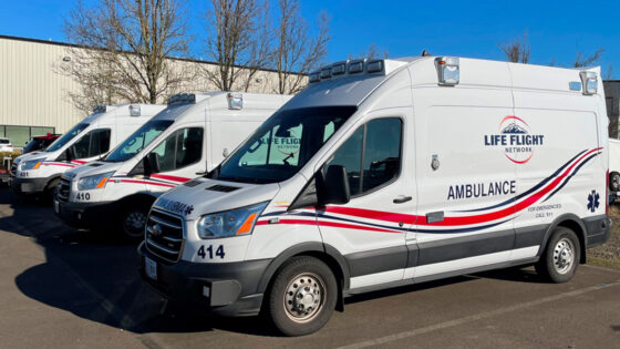 Three ground ambulances are parked in a row