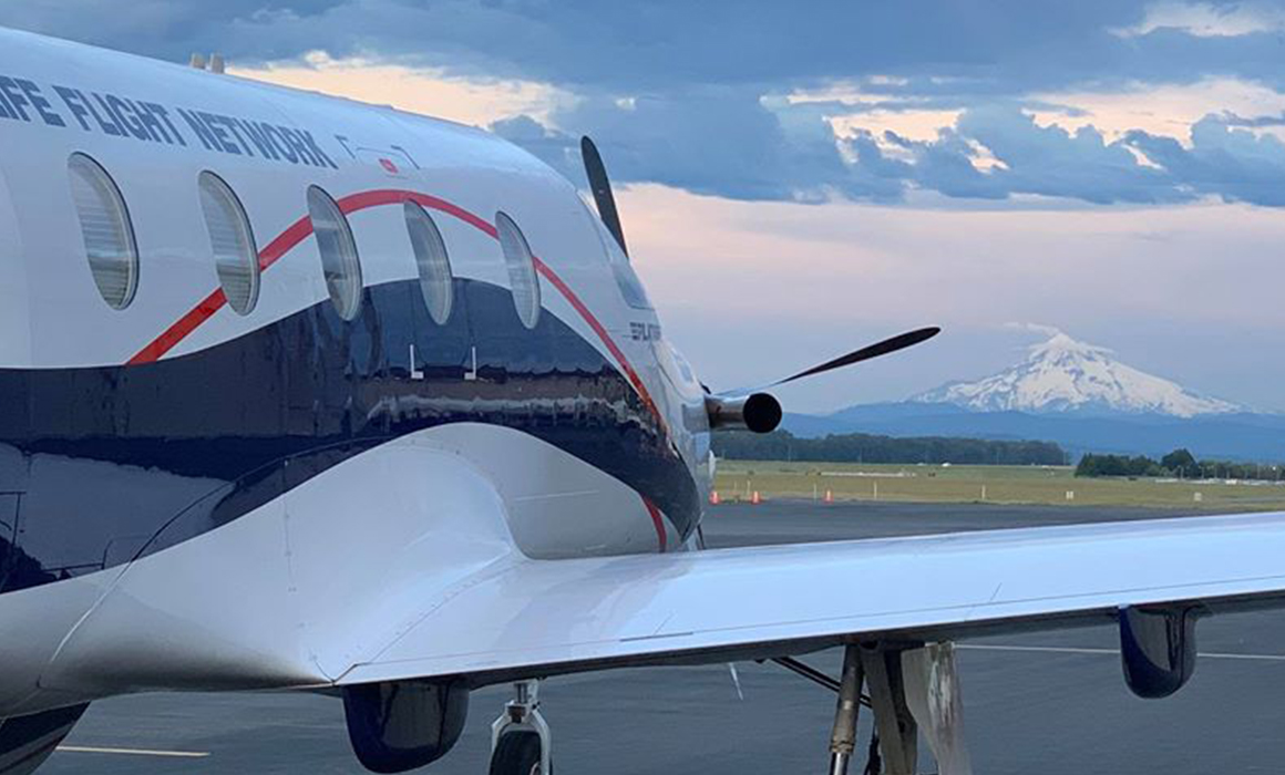 PILATUS PC-12 NG airplane is seen from behind with cloudy sky at dusk