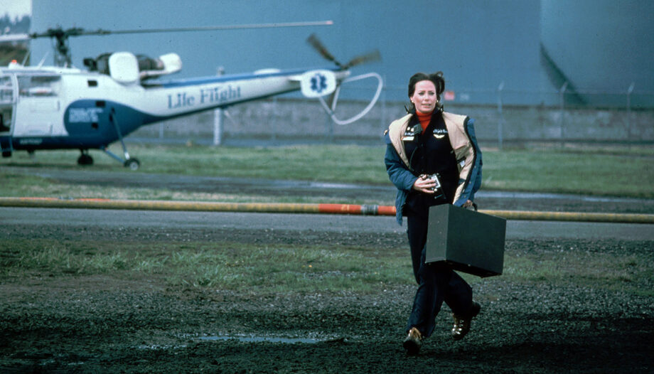 A historical photo from the '70s shows a woman with a medical case running from a just-landed helicopter